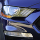 A close up photo of the headlamp on a 2020 Ford Mustang that is painted blue.